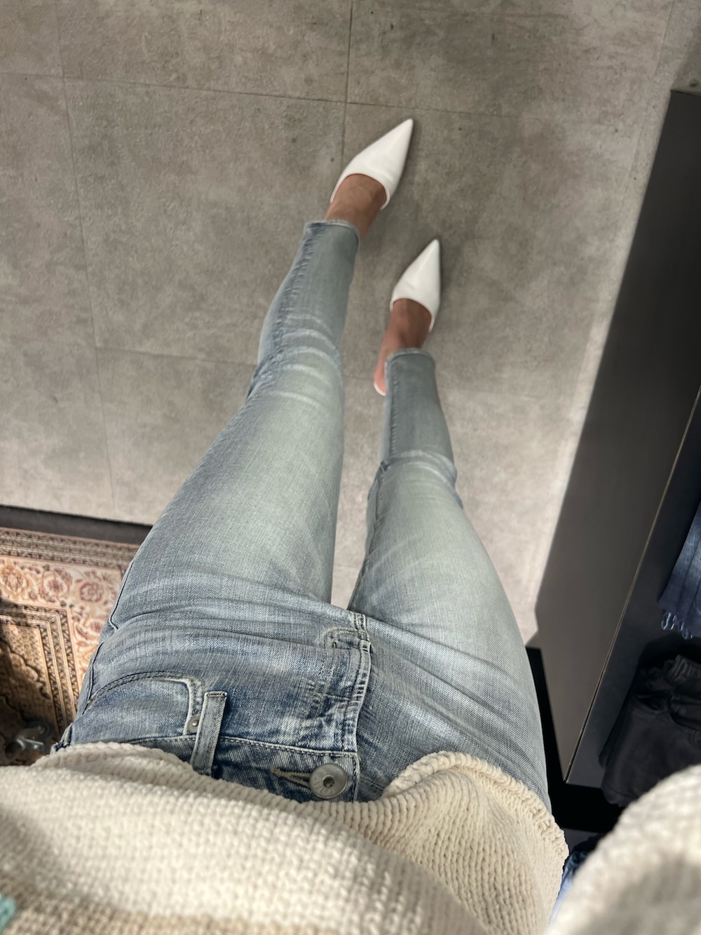 ホワイト系のニット/セーター、ブルー系のデニムパンツ、ホワイト系のハンドバッグを着用したレディースの冬コーディネートの5枚目の写真