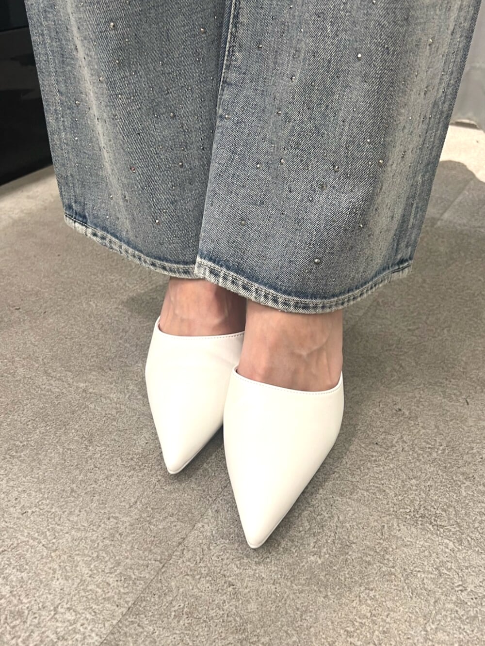 ホワイト系のTシャツ/カットソー、ブルー系のデニムパンツ、ホワイト系のパンプスを着用したレディースの春コーディネートの6枚目の写真