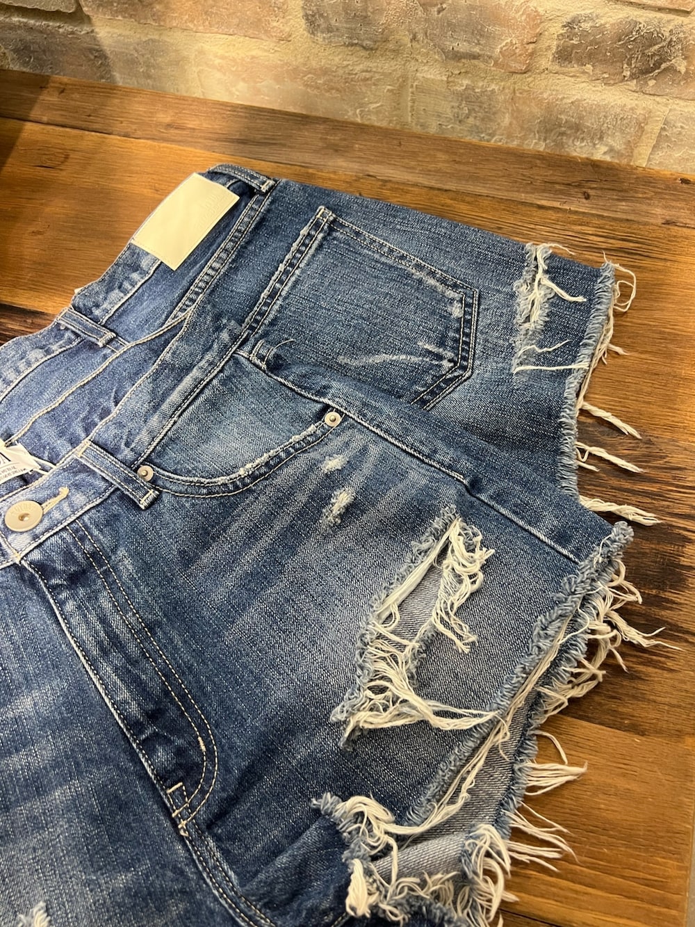 ホワイト系のブーツ、ホワイト系のTシャツ/カットソー、ブルー系のデニムパンツを着用したレディースの春コーディネートの5枚目の写真