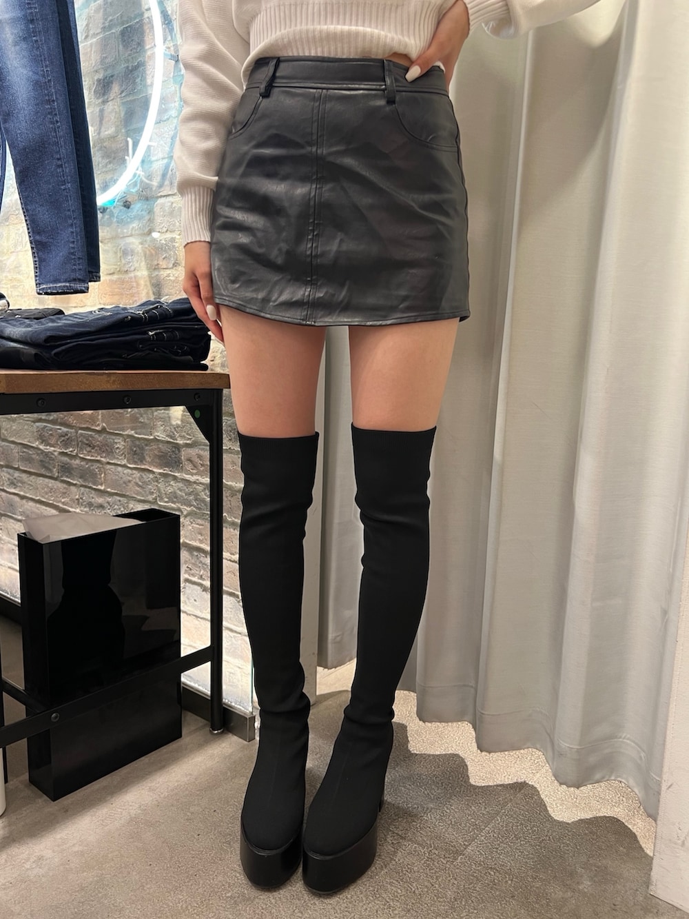 ホワイト系のムートンコート、ホワイト系のニット/セーター、ブラック系のスカートを着用したレディースの秋コーディネートの5枚目の写真