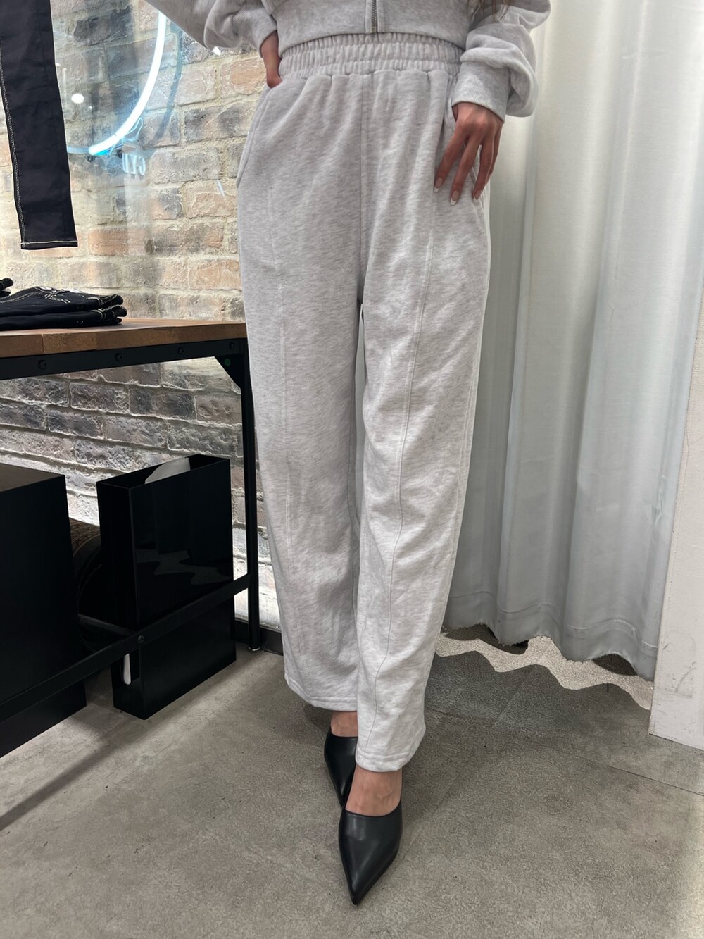 グレー系のスウェット、グレー系のスウェットパンツ、ブラック系のパンプスを着用したレディースの冬コーディネートの5枚目の写真