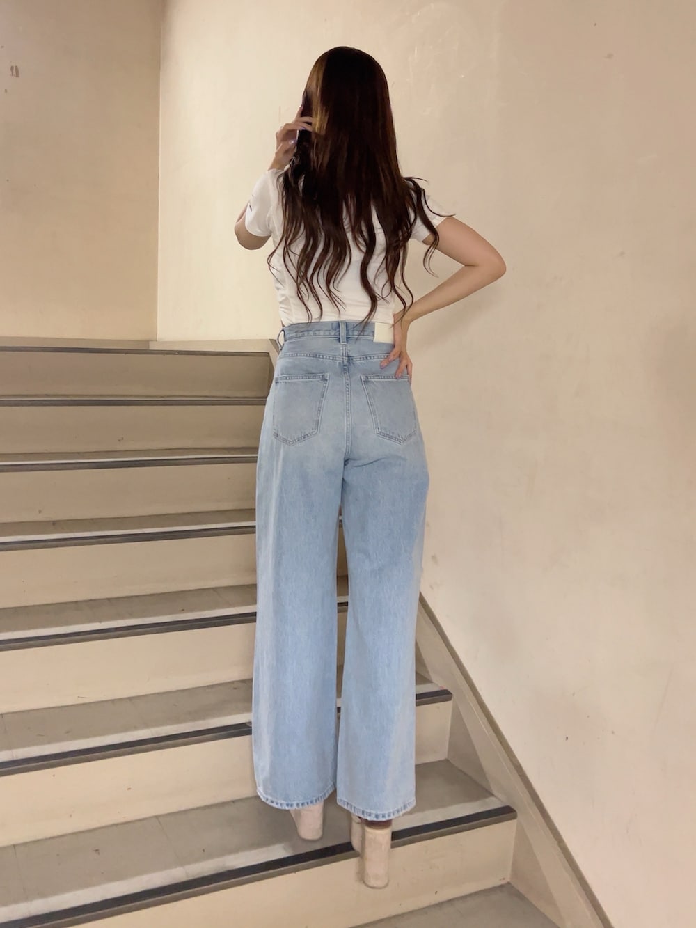 ホワイト系のTシャツ/カットソー、ブルー系のデニムパンツ、ホワイト系のサンダルを着用したレディースの夏コーディネートの3枚目の写真