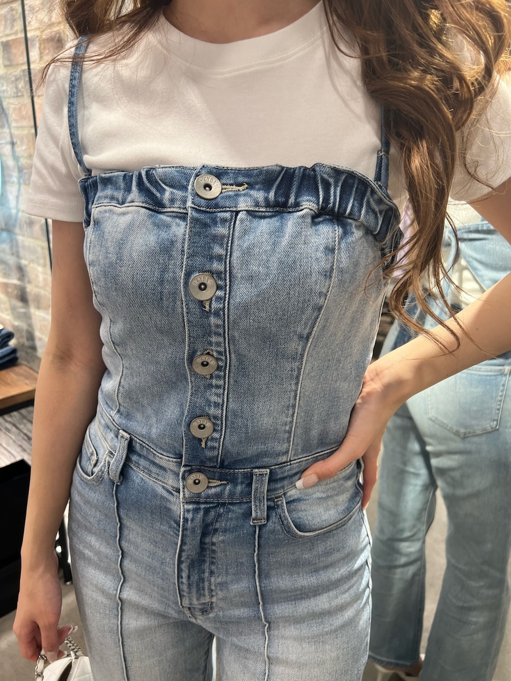 ブルー系のサロペット/オーバーオール、ホワイト系のTシャツ/カットソー、ホワイト系のパンプスを着用したレディースの冬コーディネートの3枚目の写真