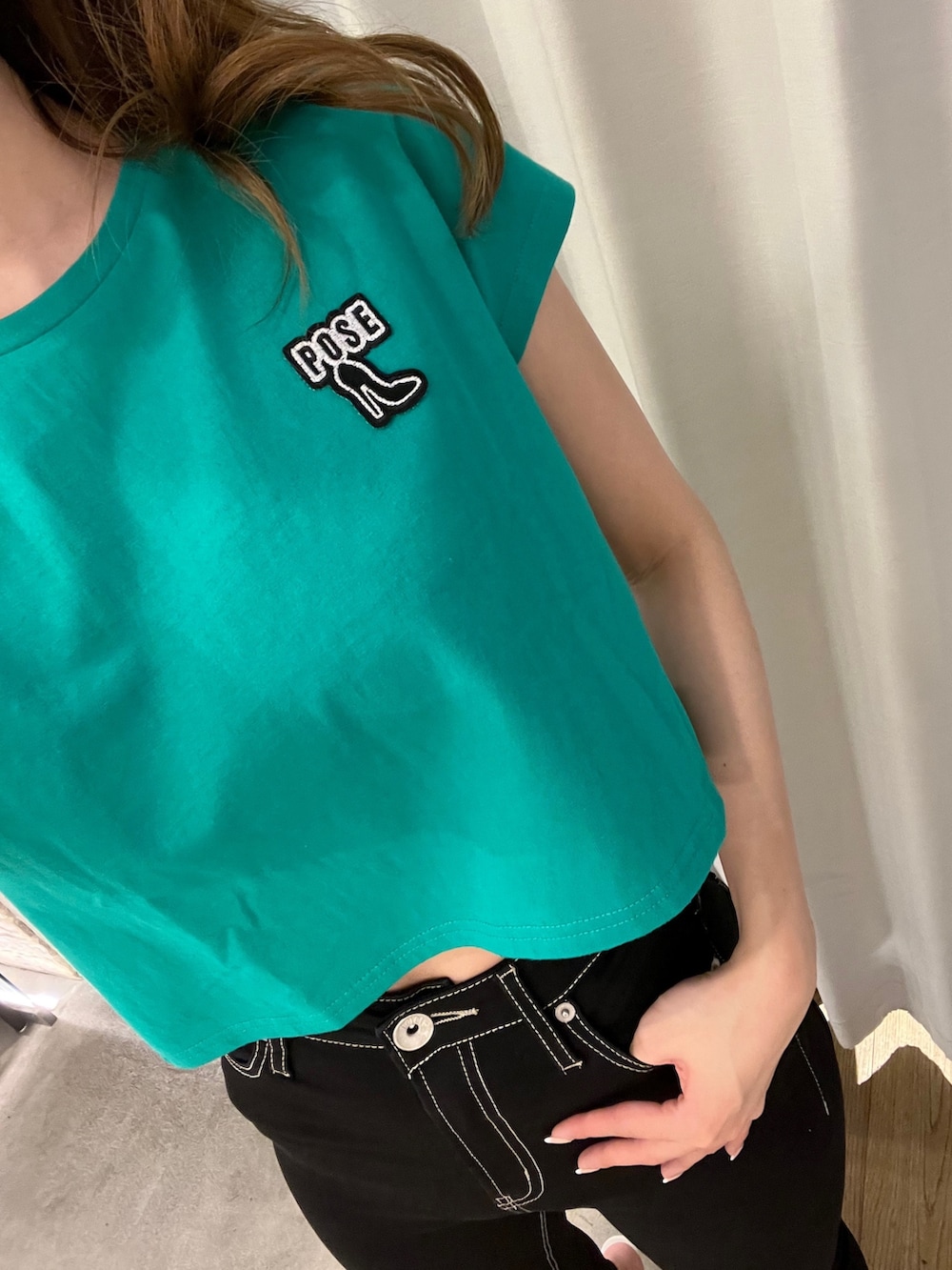 グリーン系のTシャツ/カットソー、ブラック系のデニムパンツ、ホワイト系のパンプスを着用したレディースの春コーディネートの6枚目の写真