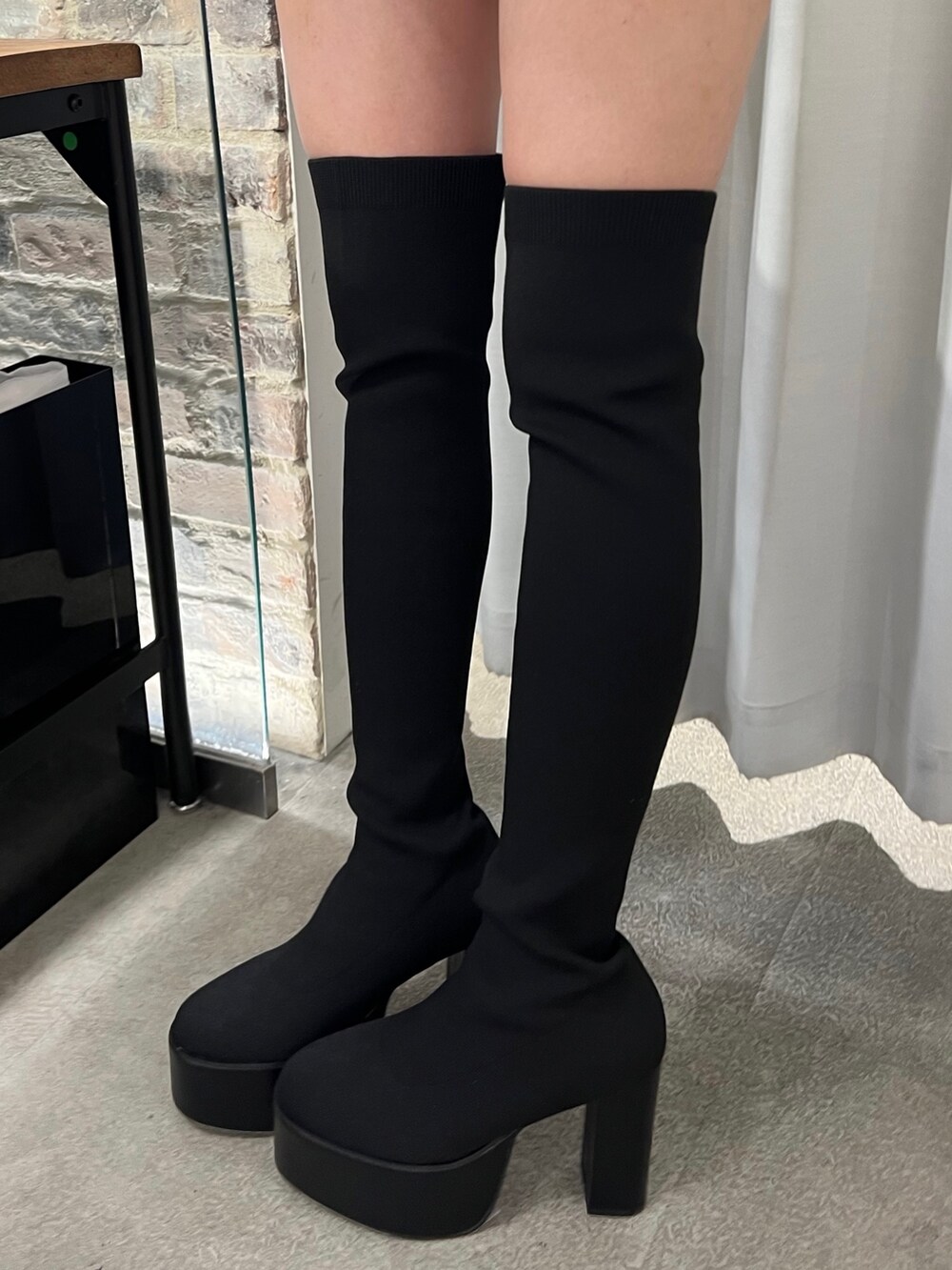 ピンク系のニット/セーター、ブラック系のデニムパンツ、ブラック系のブーツを着用したレディースの秋コーディネートの5枚目の写真