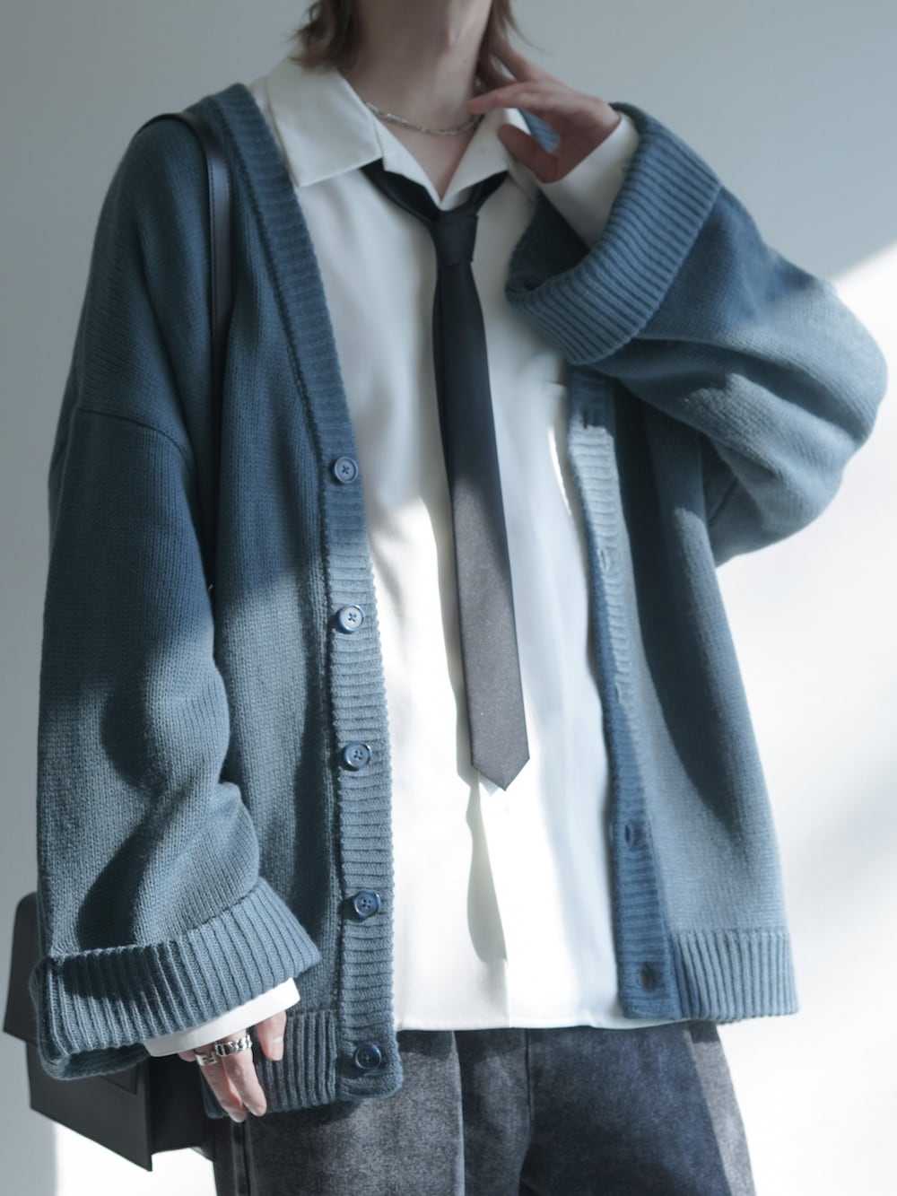 グレー系のカーディガン/ボレロ、ホワイト系のシャツ/ブラウス、ブラック系のネクタイを着用したメンズの冬コーディネートの2枚目の写真