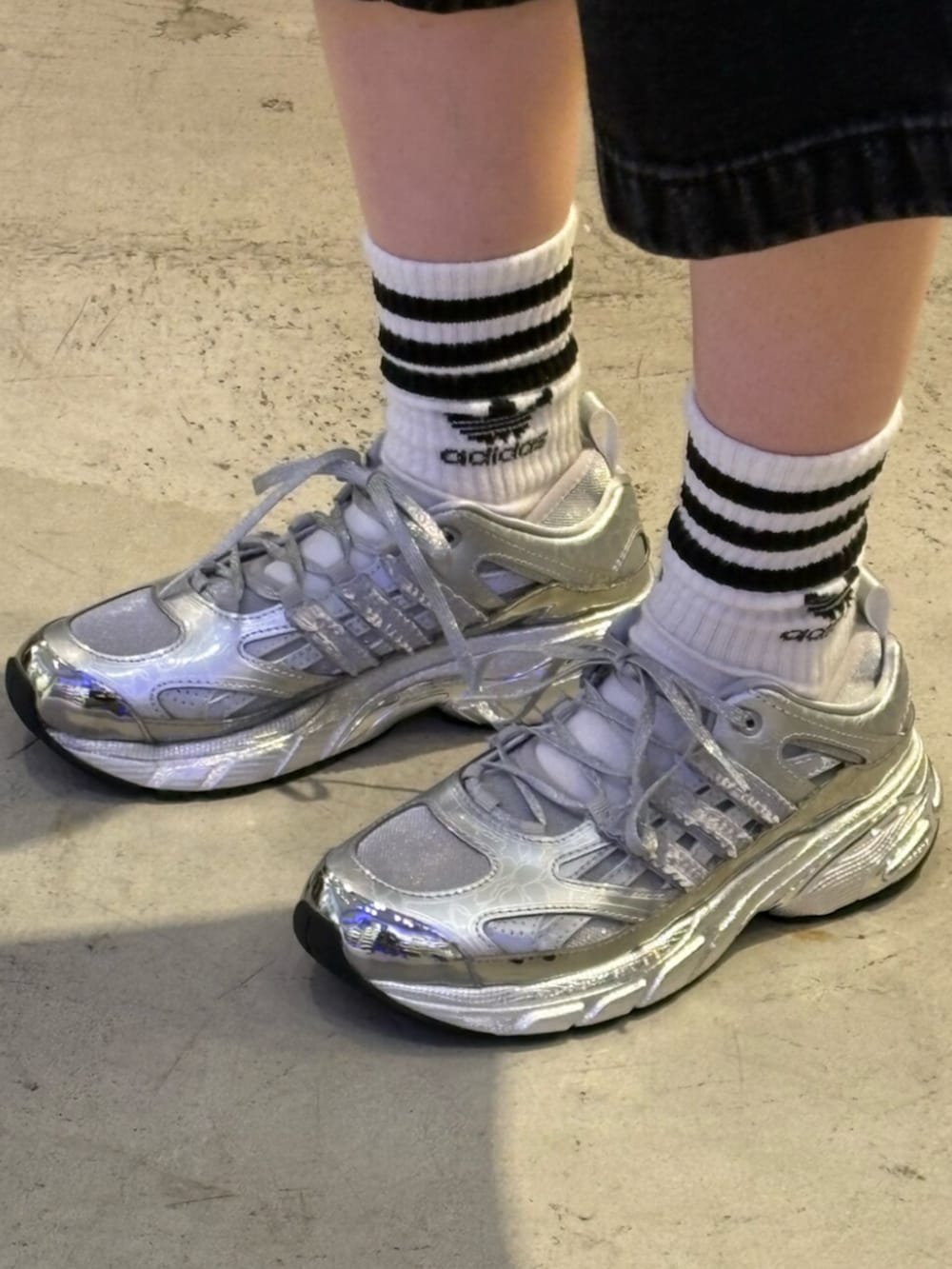 シルバー系のスニーカー、ブラック系のその他パンツ、ホワイト系のトップスを着用したレディースの春コーディネートの4枚目の写真