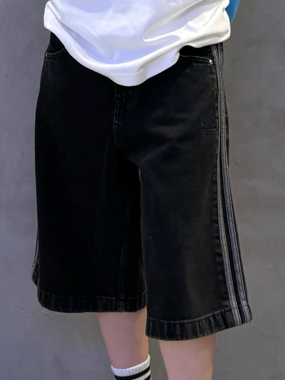 シルバー系のスニーカー、ブラック系のその他パンツ、ホワイト系のトップスを着用したレディースの春コーディネートの3枚目の写真