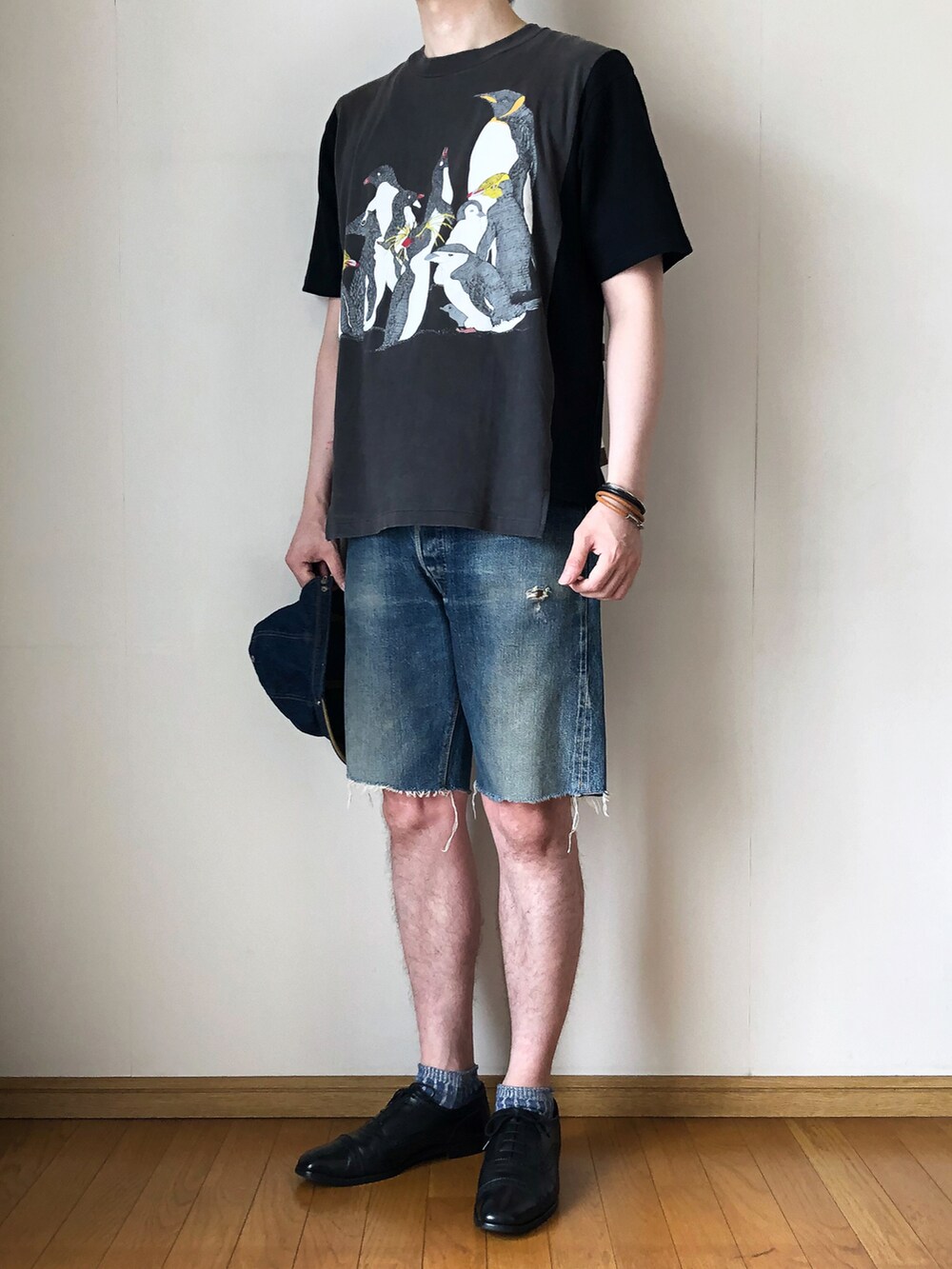 ブラック系のTシャツ/カットソー、ブルー系のデニムパンツ、ブラック系のドレスシューズを着用したメンズの夏コーディネートの2枚目の写真