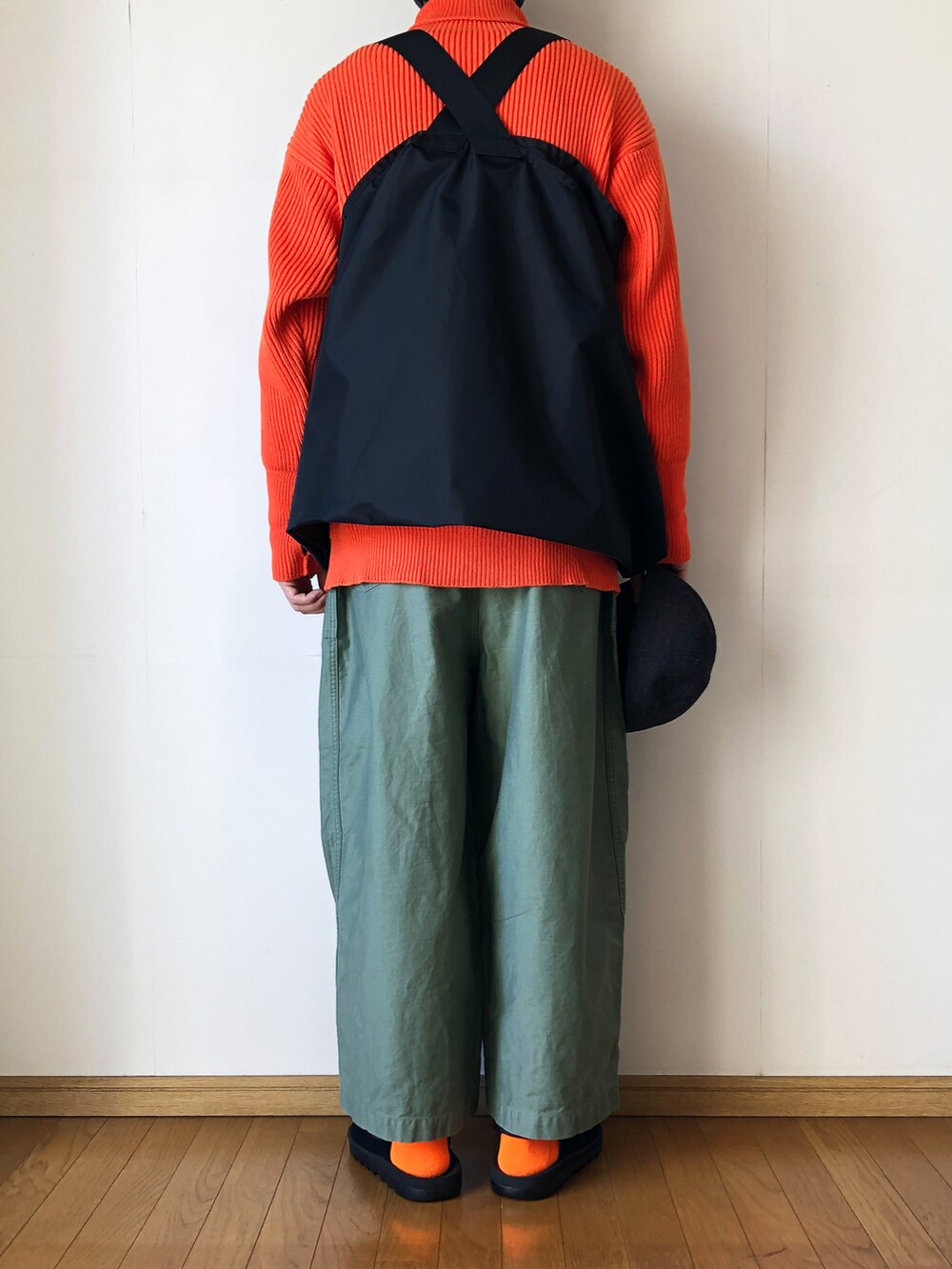 ブラック系のベスト、オレンジ系のニット/セーター、グリーン系のその他パンツを着用したメンズの冬コーディネートの4枚目の写真