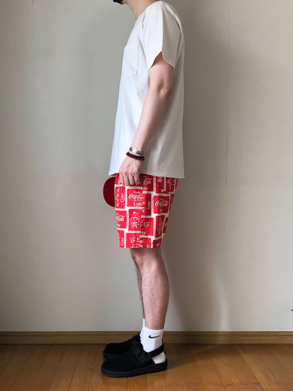 ベージュ系のTシャツ/カットソー、レッド系のその他パンツ、ブラック系のサンダルを着用したメンズの夏コーディネートの3枚目の写真