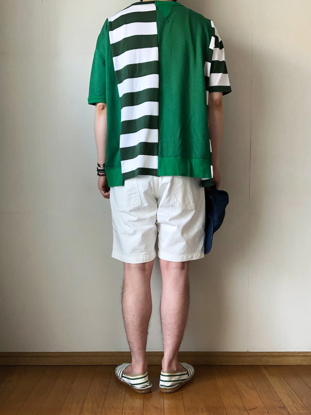 グリーン系のスウェット、ホワイト系のパンツ、グリーン系のスリッポンを着用したメンズの夏コーディネートの4枚目の写真