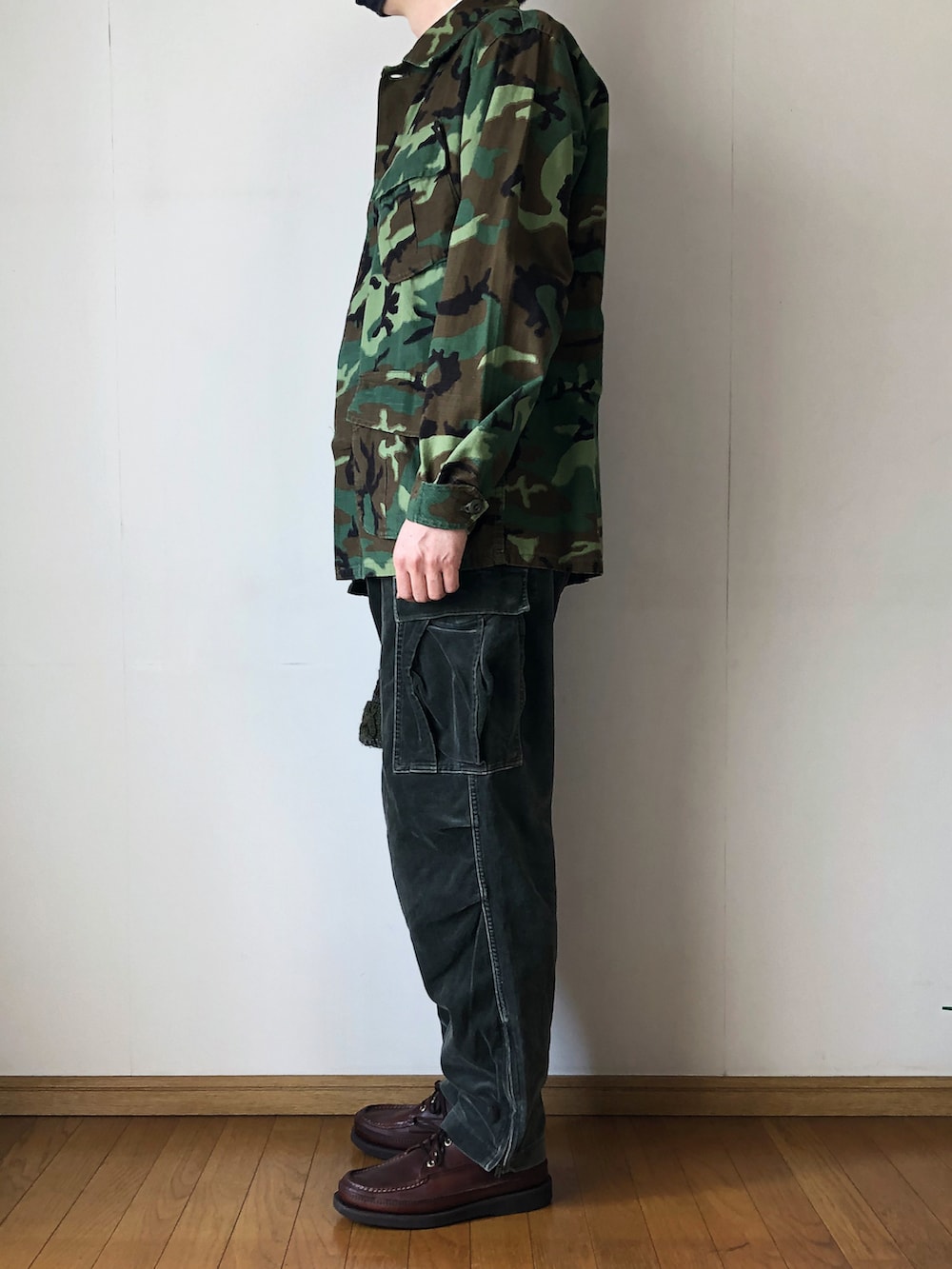 「ジャングルファティーグ、JUNGLEFATIGUE、ミリタリー、ミリタリージャケット、カモフラ、ボタンダウンシャツ、白シャツ、タックイン、カーゴパンツ、ベロアパンツ、ニット帽、ポンポン帽子、ケーブルニット、モカシン、ブーツ」|「MILITARYのJUNGLE FATIGUE JACKET(ミリタリージャケット、グリーン系)」を使った、となりさん(メンズ・179cm)の春コーディネートの3枚目の写真
