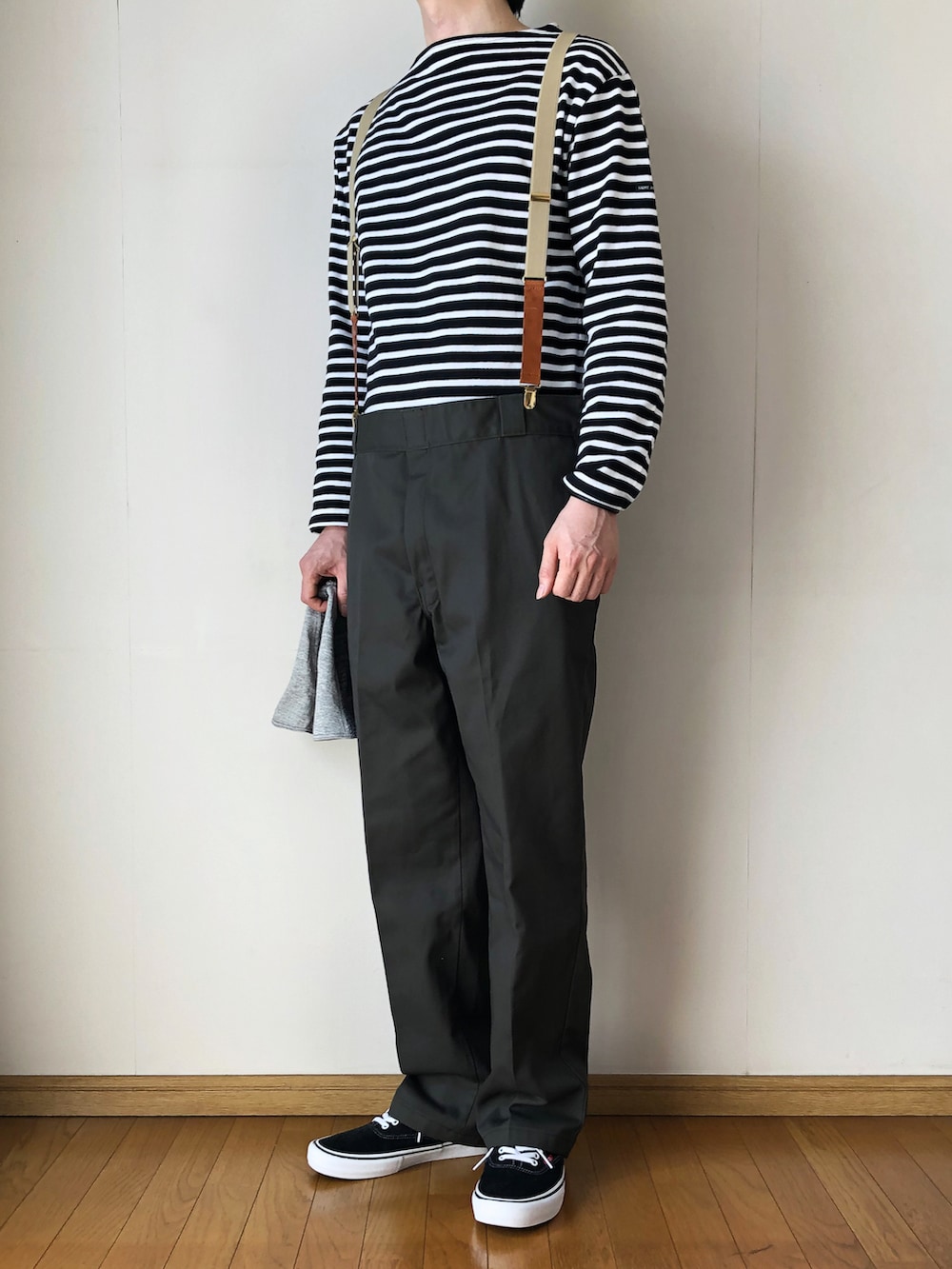 ブラック系のTシャツ/カットソー、グリーン系のチノパンツ、ブラック系のスニーカーを着用したメンズの春コーディネートの2枚目の写真