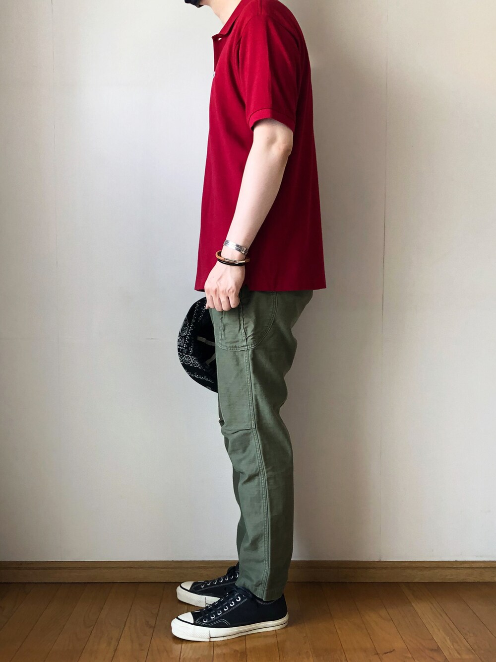 レッド系のポロシャツ、グリーン系のカーゴパンツ、ブラック系のスニーカーを着用したメンズの夏コーディネートの3枚目の写真