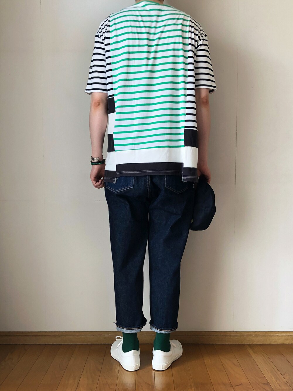 グリーン系のTシャツ/カットソー、ブルー系のデニムパンツ、ホワイト系のスニーカーを着用したメンズの夏コーディネートの4枚目の写真