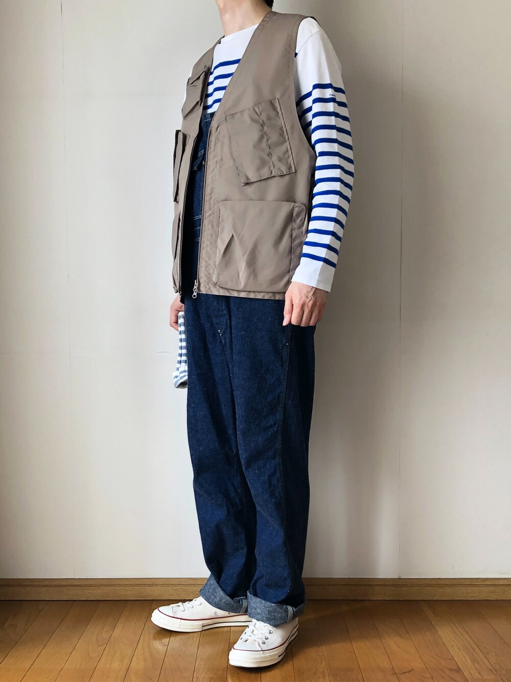 ベージュ系のベスト、ブルー系のTシャツ/カットソー、ブルー系のサロペット/オーバーオールを着用したメンズの春コーディネートの2枚目の写真
