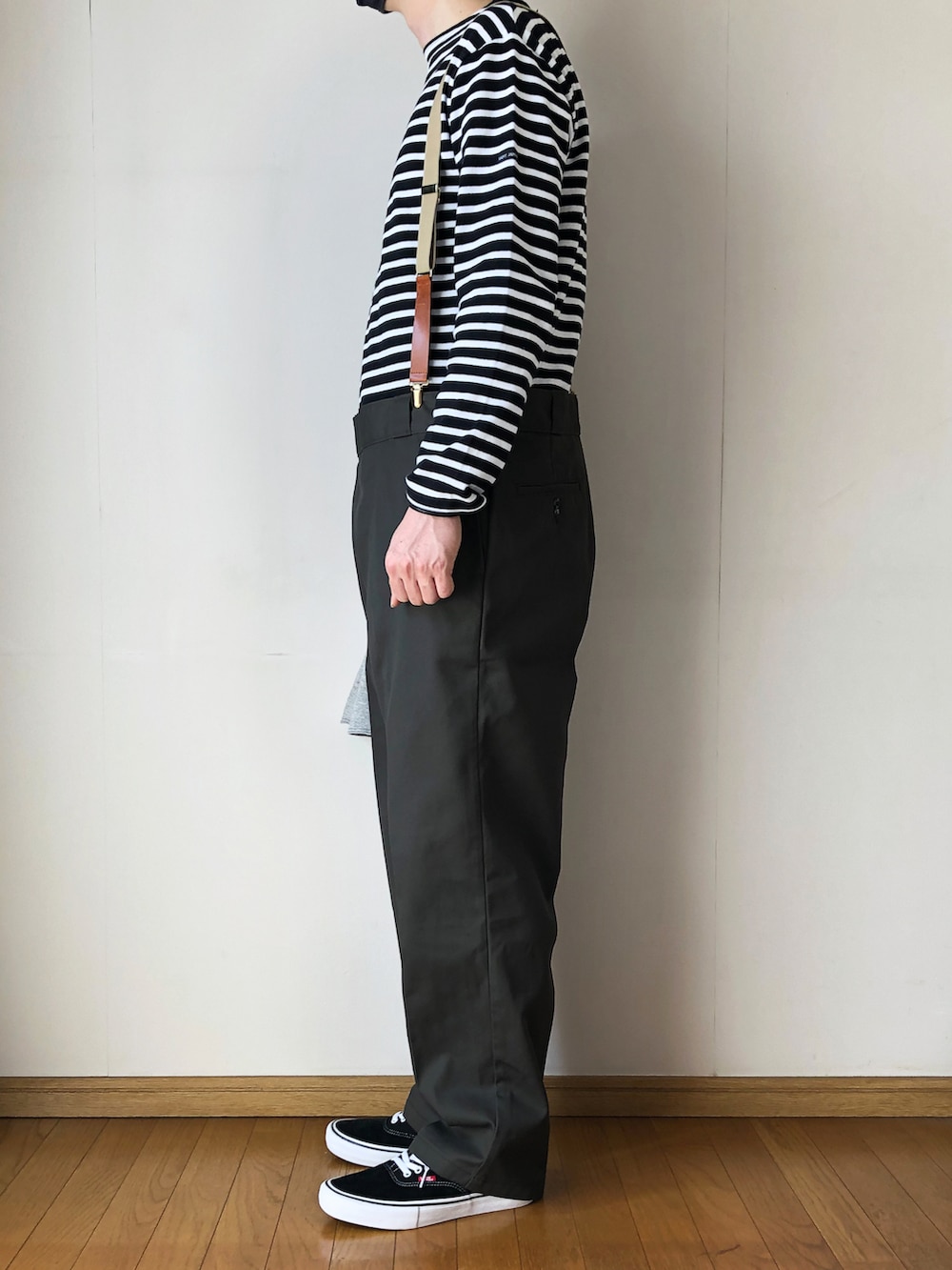 ブラック系のTシャツ/カットソー、グリーン系のチノパンツ、ブラック系のスニーカーを着用したメンズの春コーディネートの3枚目の写真