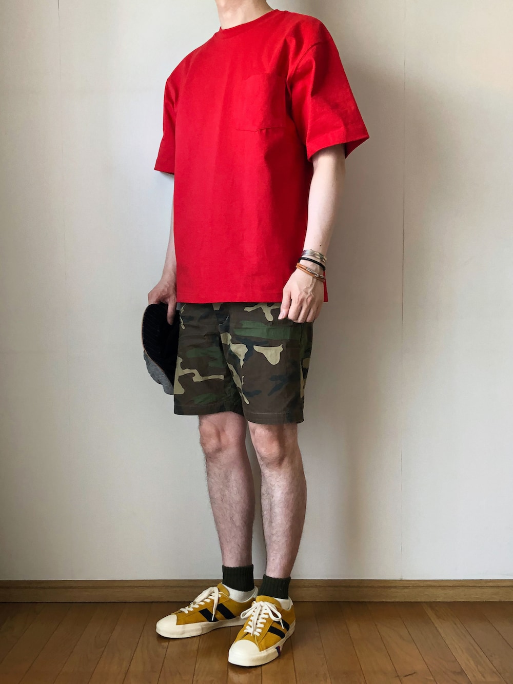 レッド系のTシャツ/カットソー、ブラウン系のパンツ、ゴールド系のスニーカーを着用したメンズの春コーディネートの2枚目の写真