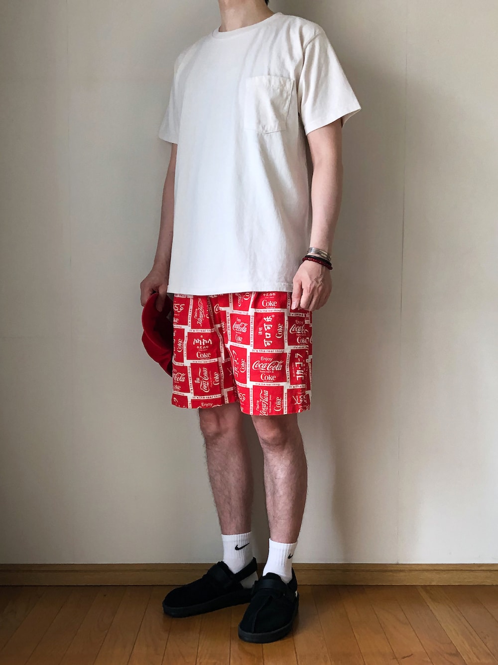 ベージュ系のTシャツ/カットソー、レッド系のその他パンツ、ブラック系のサンダルを着用したメンズの夏コーディネートの2枚目の写真