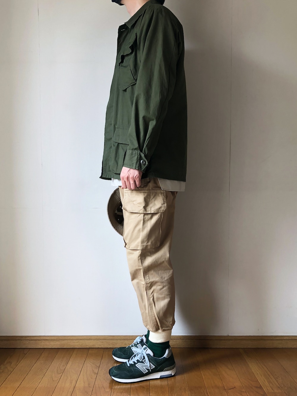 グリーン系のミリタリージャケット、ベージュ系のシャツ/ブラウス、ベージュ系のカーゴパンツを着用したメンズの春コーディネートの3枚目の写真