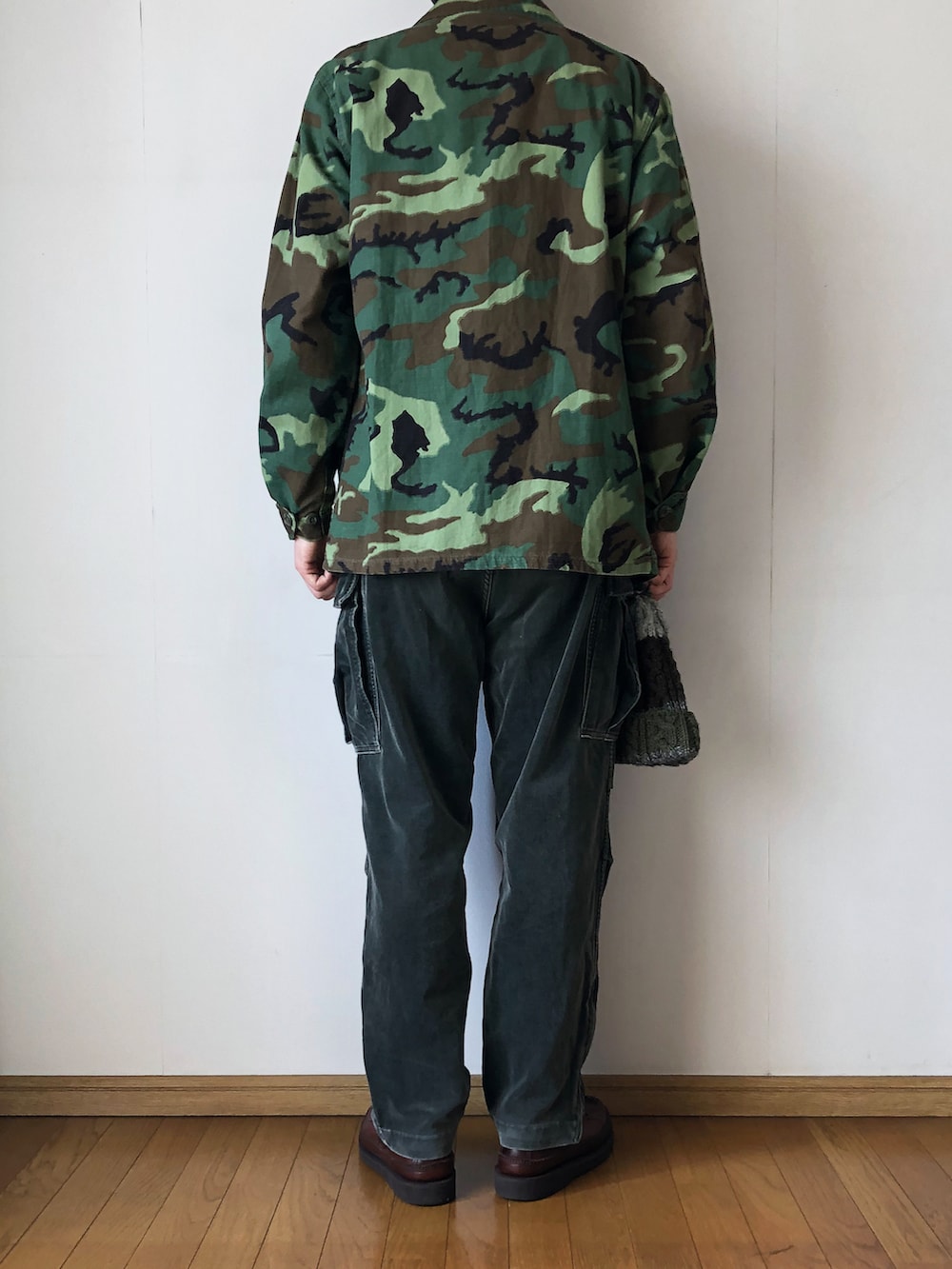「ジャングルファティーグ、JUNGLEFATIGUE、ミリタリー、ミリタリージャケット、カモフラ、ボタンダウンシャツ、白シャツ、タックイン、カーゴパンツ、ベロアパンツ、ニット帽、ポンポン帽子、ケーブルニット、モカシン、ブーツ」|「MILITARYのJUNGLE FATIGUE JACKET(ミリタリージャケット、グリーン系)」を使った、となりさん(メンズ・179cm)の春コーディネートの4枚目の写真