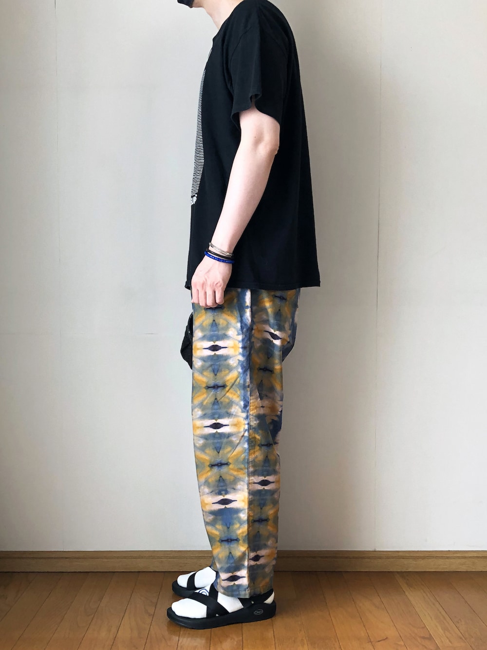 ブラック系のTシャツ/カットソー、ブルー系のその他パンツ、ブラック系のサンダルを着用したメンズの夏コーディネートの3枚目の写真