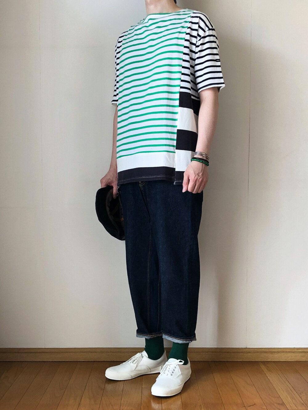 グリーン系のTシャツ/カットソー、ブルー系のデニムパンツ、ホワイト系のスニーカーを着用したメンズの夏コーディネートの2枚目の写真