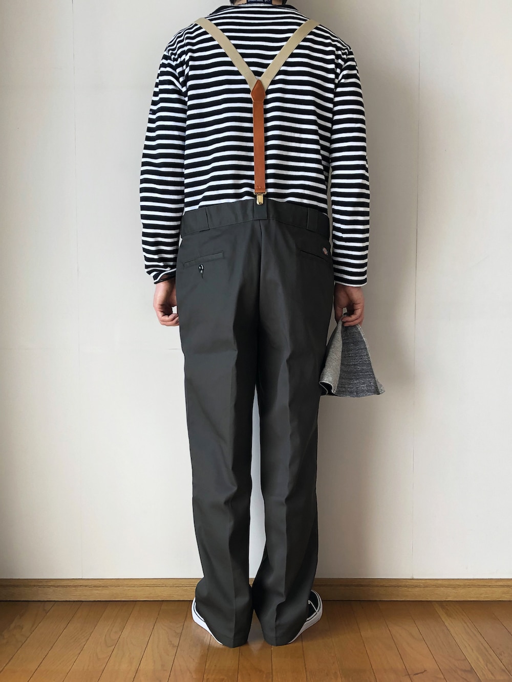 ブラック系のTシャツ/カットソー、グリーン系のチノパンツ、ブラック系のスニーカーを着用したメンズの春コーディネートの4枚目の写真