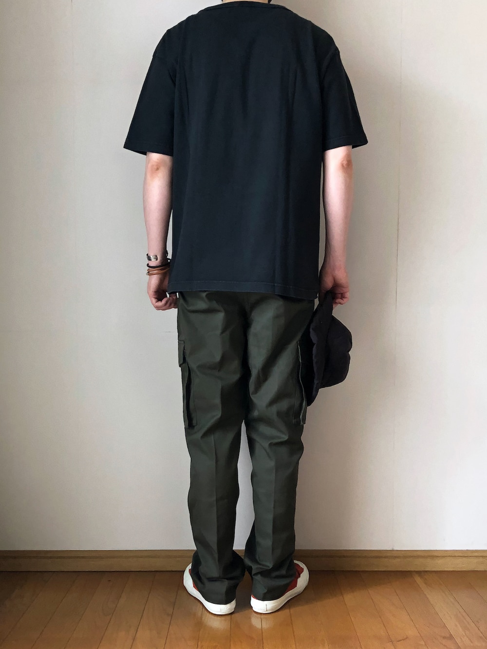 ブラック系のTシャツ/カットソー、グリーン系のカーゴパンツ、オレンジ系のスニーカーを着用したメンズの夏コーディネートの4枚目の写真