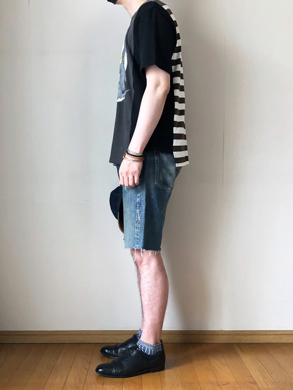 ブラック系のTシャツ/カットソー、ブルー系のデニムパンツ、ブラック系のドレスシューズを着用したメンズの夏コーディネートの3枚目の写真