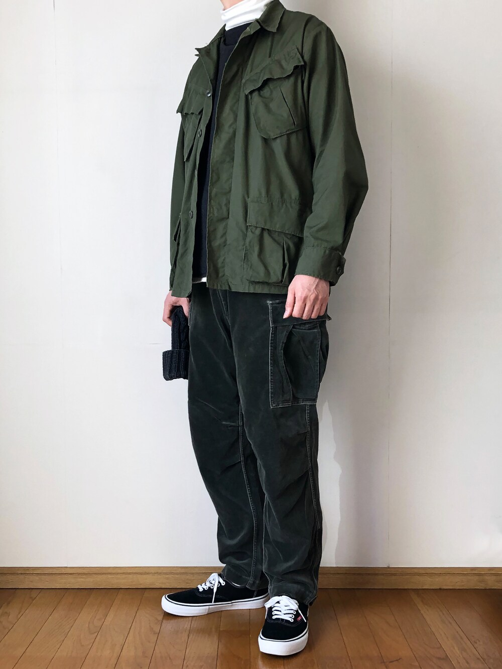 グリーン系のミリタリージャケット、グレー系のベスト、ホワイト系のTシャツ/カットソーを着用したメンズの冬コーディネートの2枚目の写真