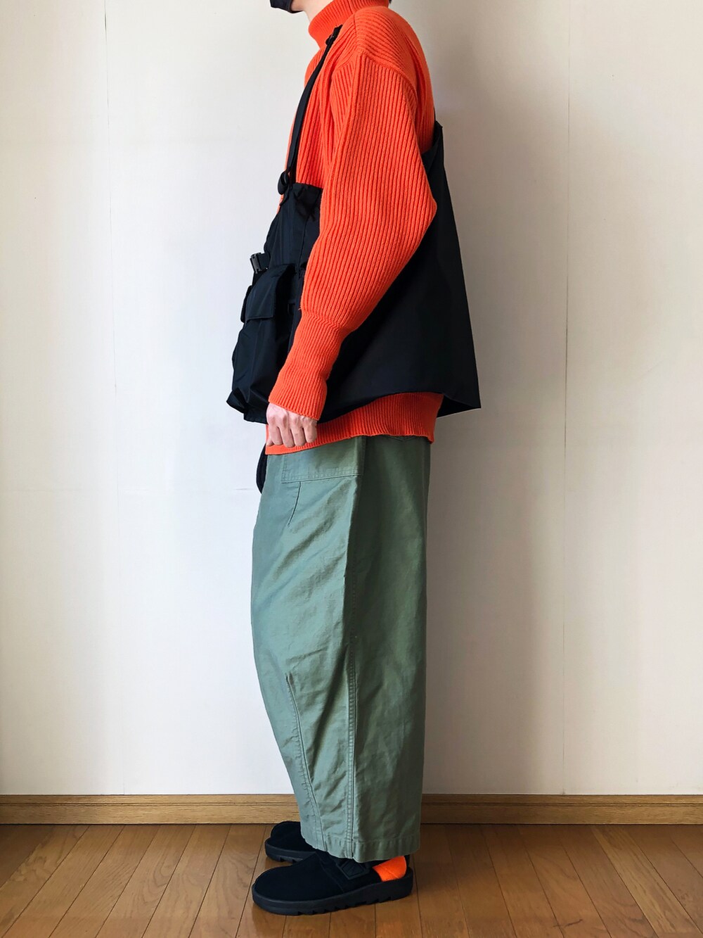 ブラック系のベスト、オレンジ系のニット/セーター、グリーン系のその他パンツを着用したメンズの冬コーディネートの3枚目の写真