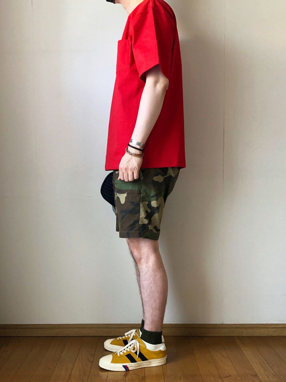 レッド系のTシャツ/カットソー、ブラウン系のパンツ、ゴールド系のスニーカーを着用したメンズの春コーディネートの3枚目の写真