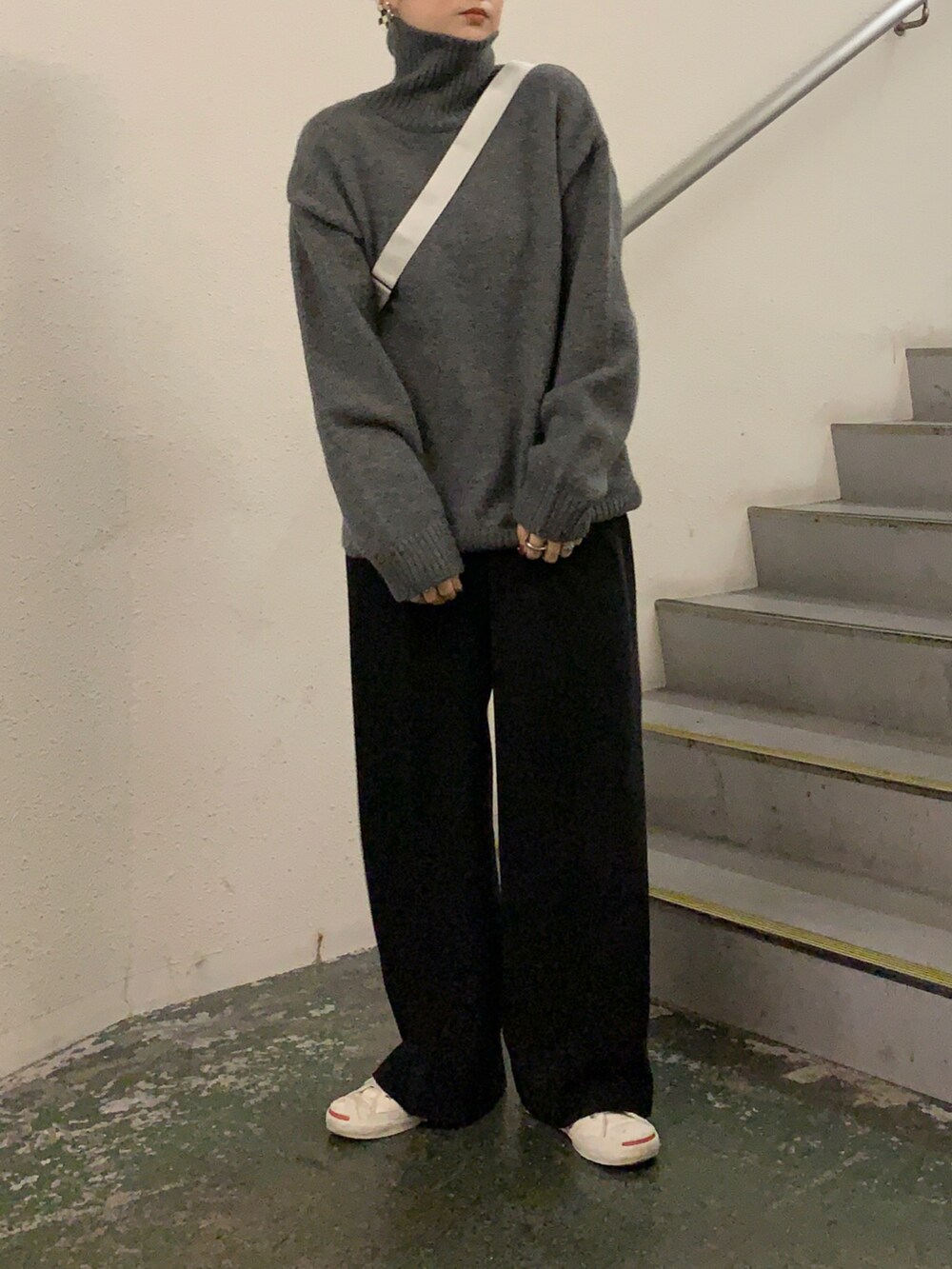 グレー系のニット/セーター、ホワイト系のショルダーバッグ、ブラック系のその他パンツを着用したレディースの冬コーディネートの2枚目の写真