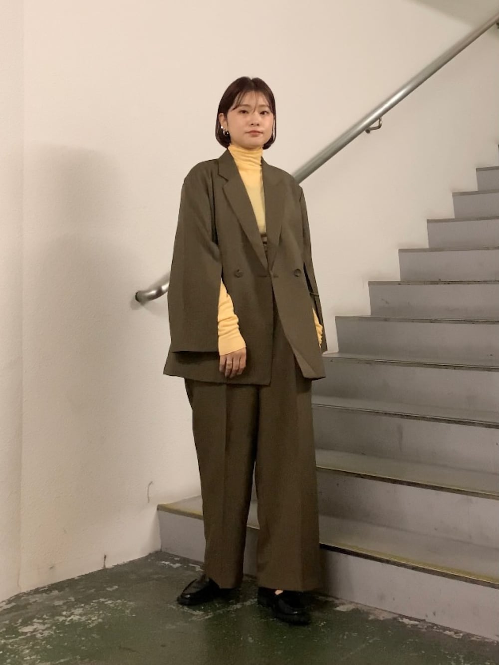 オレンジ系のTシャツ/カットソー、グレー系のその他アウター、グレー系のその他パンツを着用したレディースの秋コーディネートの5枚目の写真