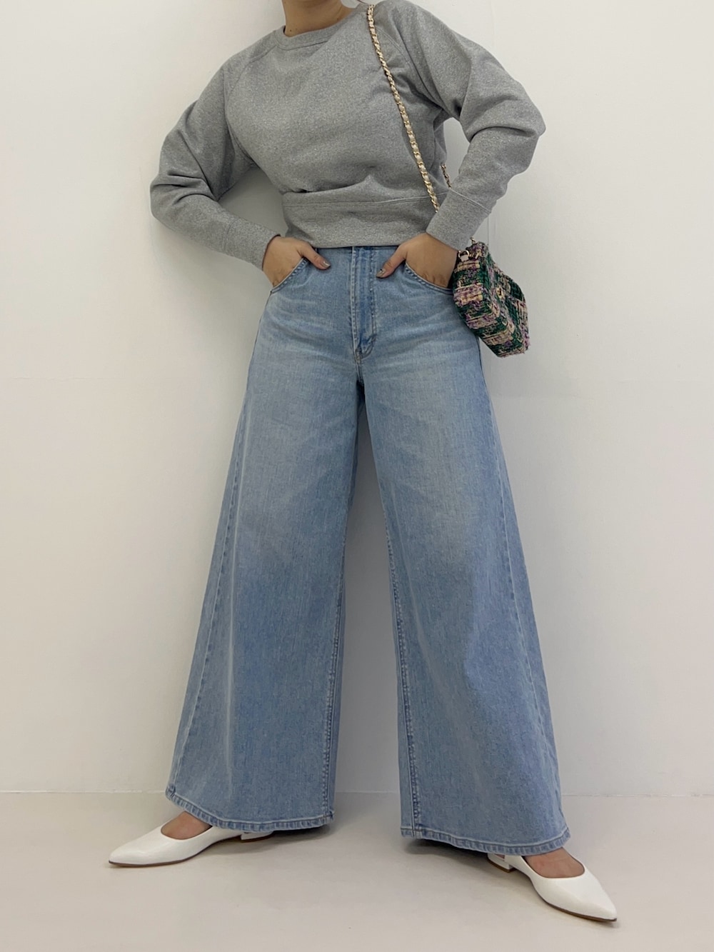 グレー系のTシャツ/カットソー、ブルー系のデニムパンツ、グリーン系のショルダーバッグを着用したレディースの冬コーディネートの2枚目の写真