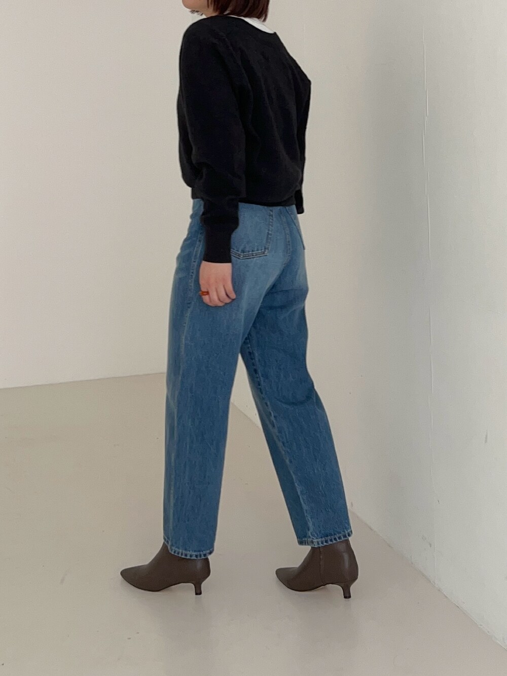 ブルー系のデニムパンツ、グレー系のニット/セーターを着用したレディースの秋コーディネートの4枚目の写真