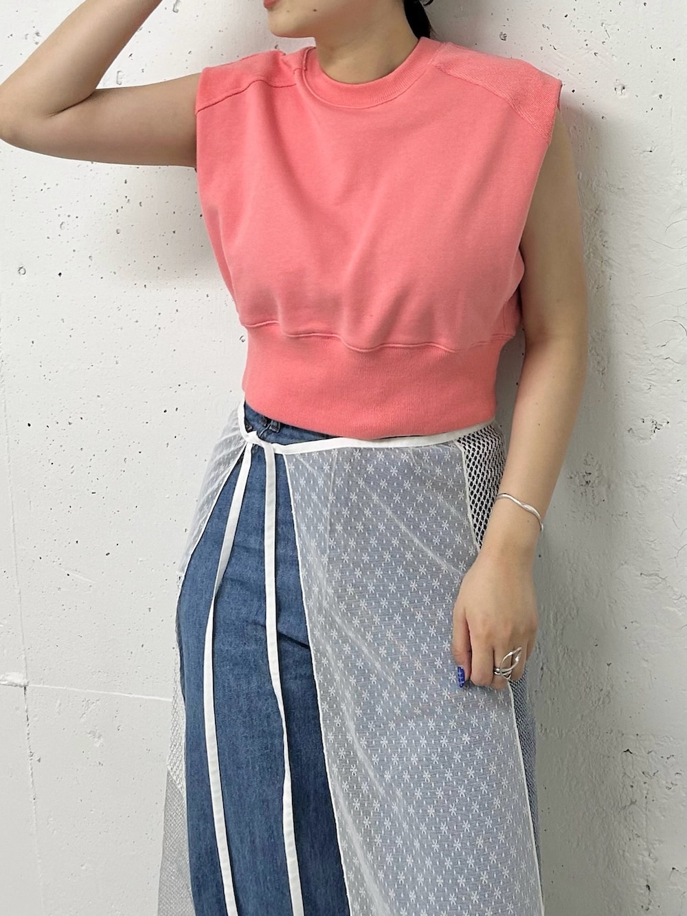 ピンク系のスウェット、ホワイト系のスカート、ブルー系のデニムパンツを着用したレディースの夏コーディネートの2枚目の写真