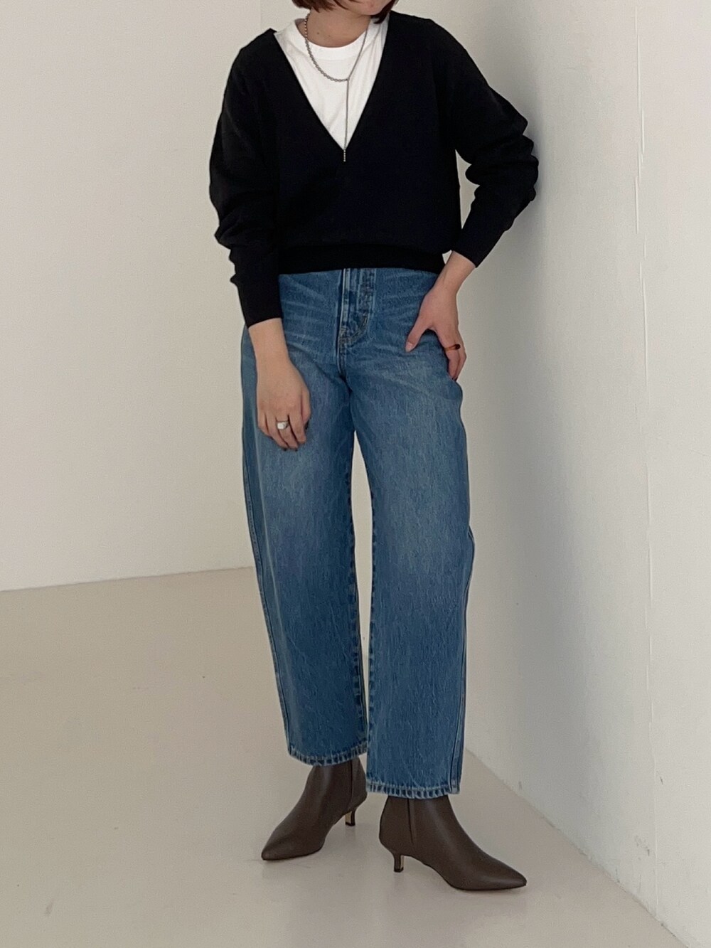 ブルー系のデニムパンツ、グレー系のニット/セーターを着用したレディースの秋コーディネートの3枚目の写真