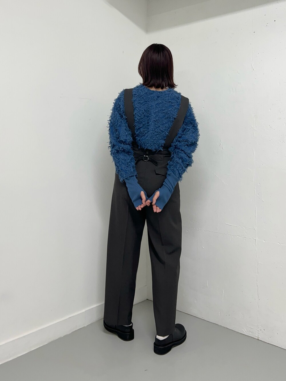 グレー系のサロペット/オーバーオール、ブルー系のカーディガン/ボレロ、ブラック系のブーツを着用したレディースの冬コーディネートの3枚目の写真