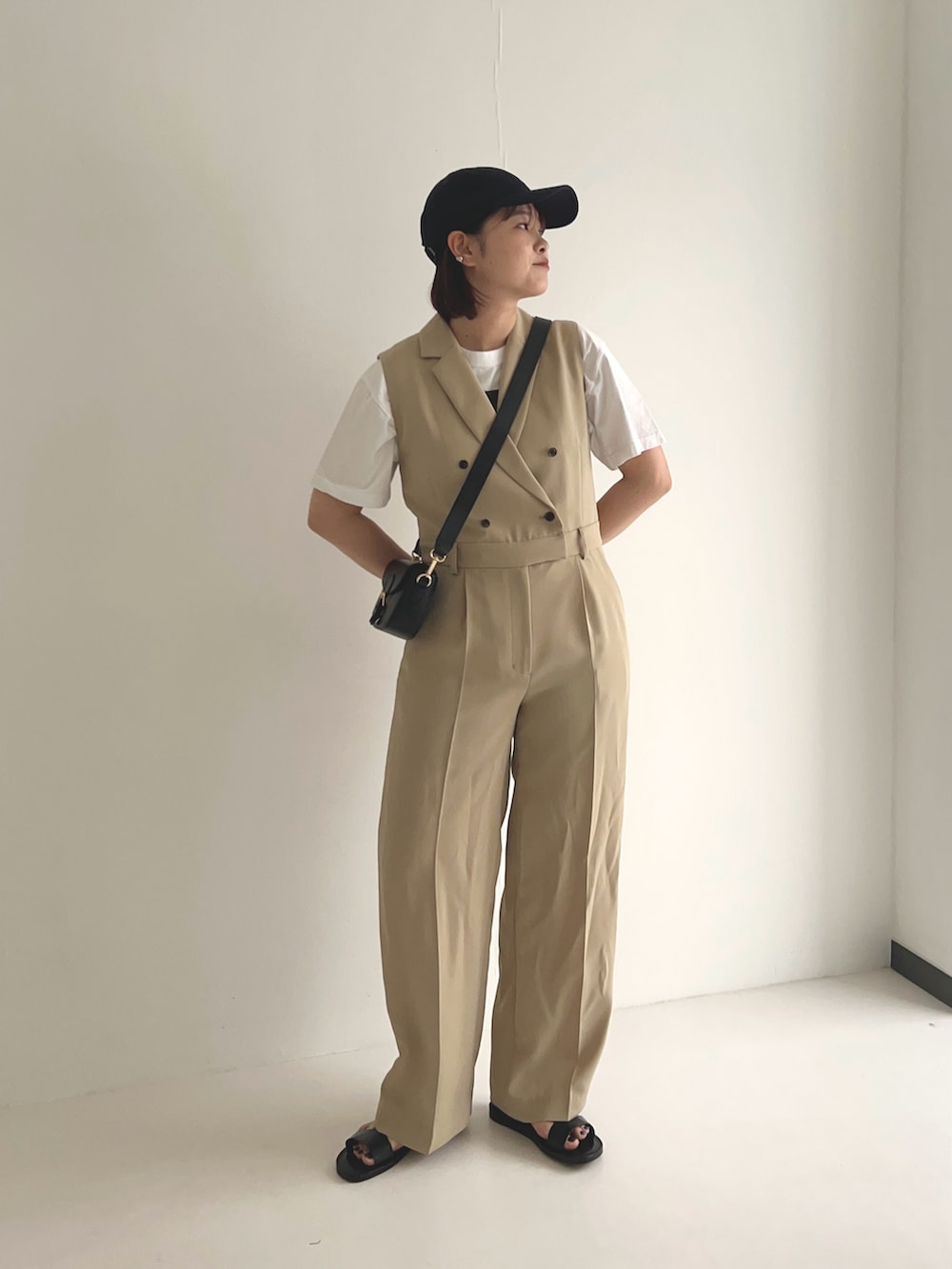 ベージュ系のワンピース、ブラック系のショルダーバッグ、ブラック系のサンダルを着用したレディースの夏コーディネートの3枚目の写真