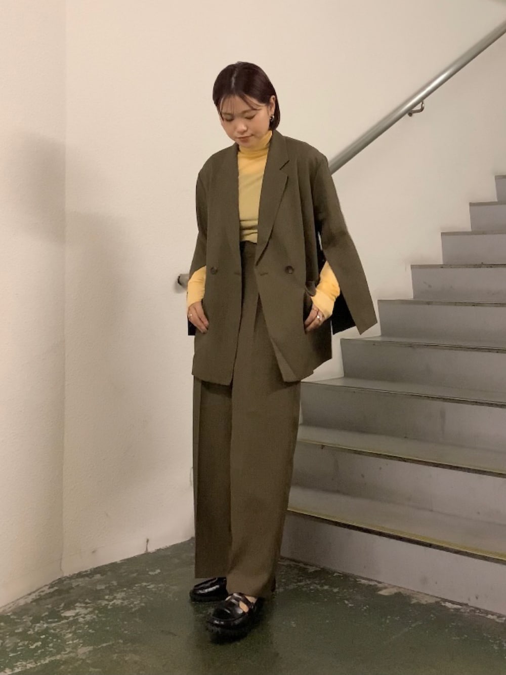 オレンジ系のTシャツ/カットソー、グレー系のその他アウター、グレー系のその他パンツを着用したレディースの秋コーディネートの3枚目の写真