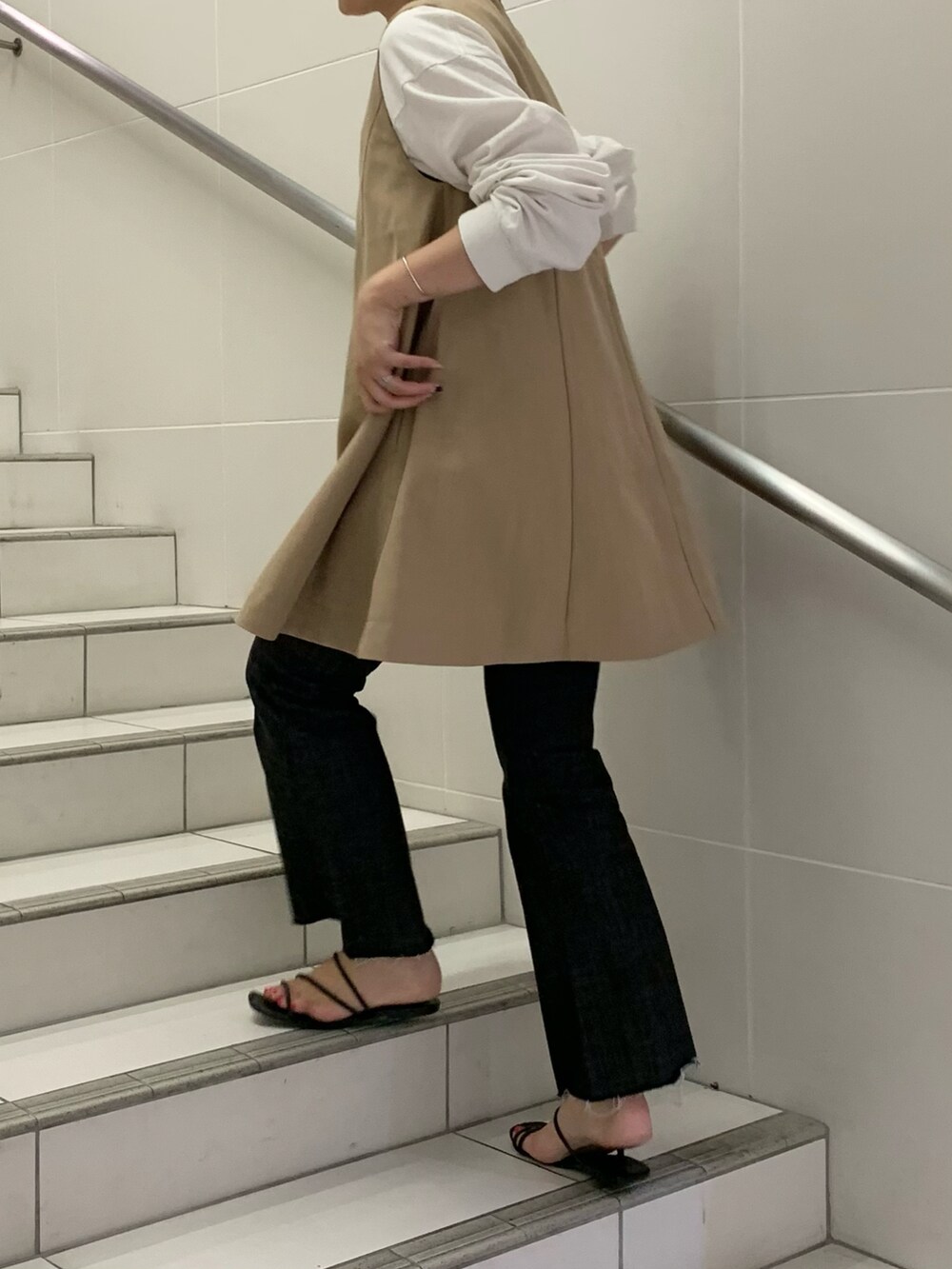 ブラック系のパンツ、ベージュ系のワンピース/ドレス、グリーン系のトートバッグを着用したレディースの夏コーディネートの3枚目の写真