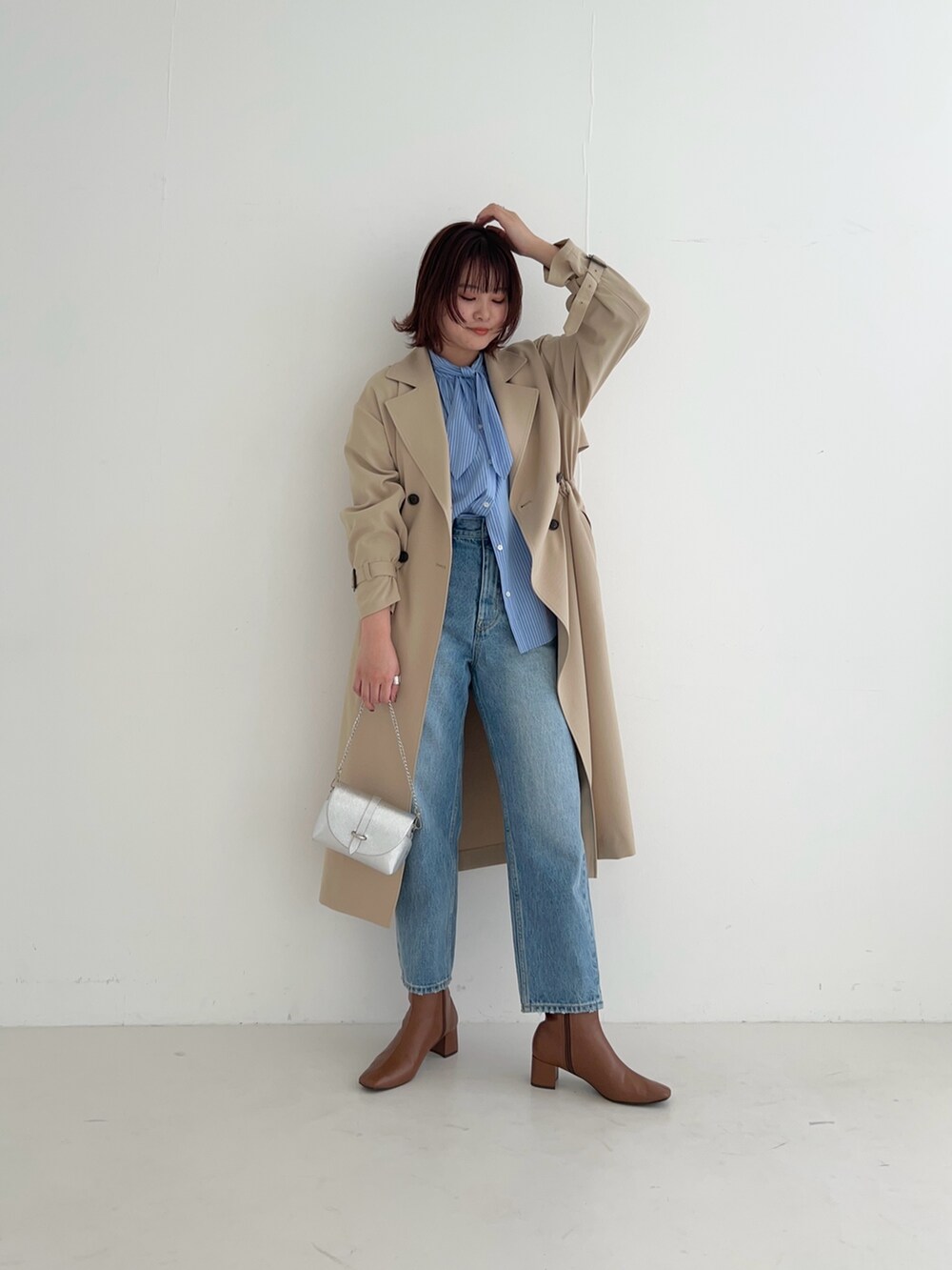 ベージュ系のトレンチコート、ブルー系のデニムパンツ、その他のシャツ/ブラウスを着用したレディースの冬コーディネートの3枚目の写真