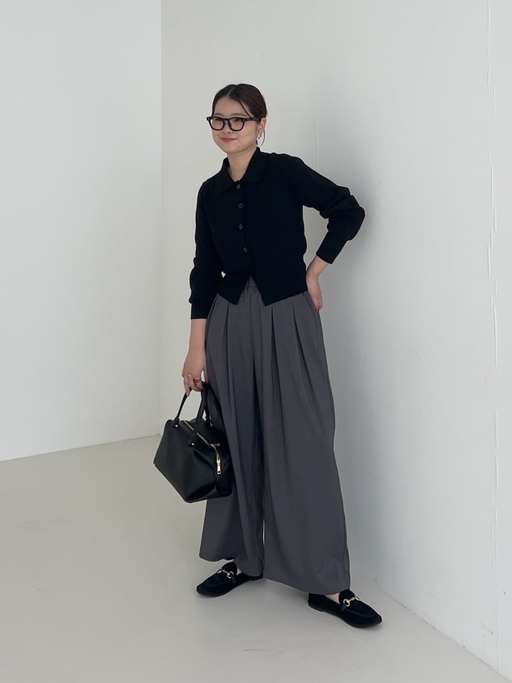 グレー系のその他パンツ、ブラック系のカーディガン/ボレロ、ブラック系のハンドバッグを着用したレディースの秋コーディネートの2枚目の写真