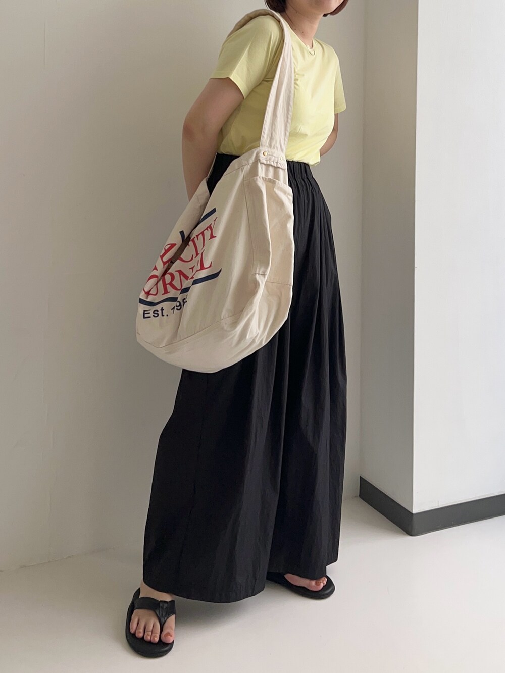 イエロー系のTシャツ/カットソー、ブラック系のその他パンツを着用したレディースの夏コーディネートの2枚目の写真