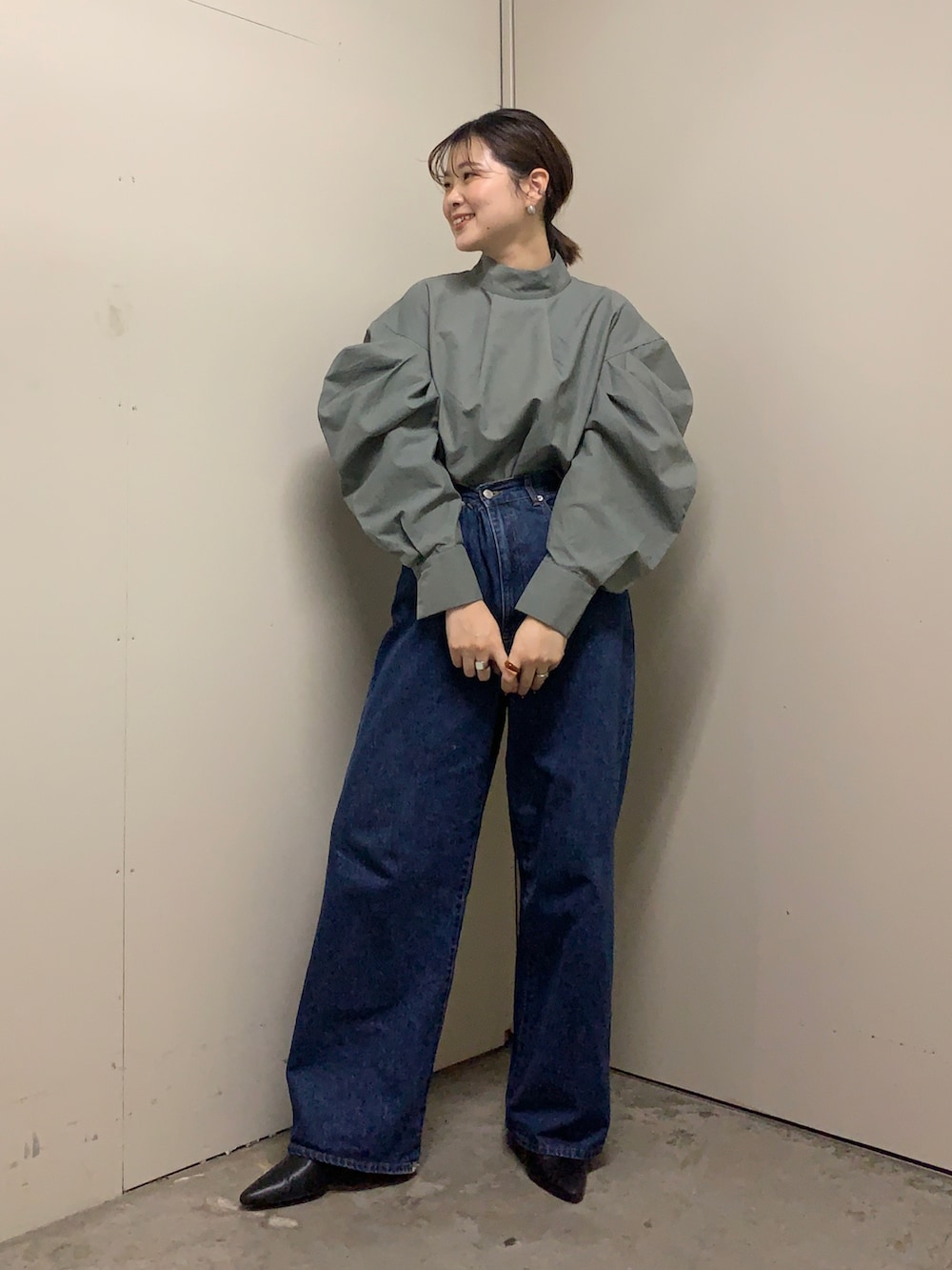 ブルー系のデニムパンツ、グレー系のシャツ/ブラウス、ブラック系のブーツを着用したレディースの冬コーディネートの2枚目の写真