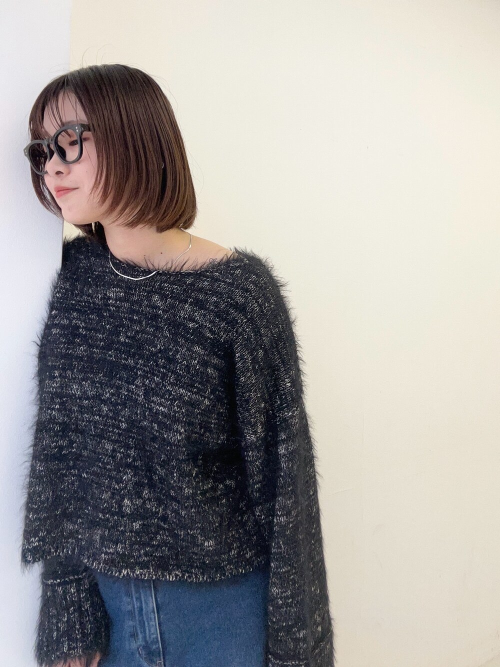 ブラック系のニット/セーター、ブルー系のデニムパンツを着用したレディースの秋コーディネートの5枚目の写真