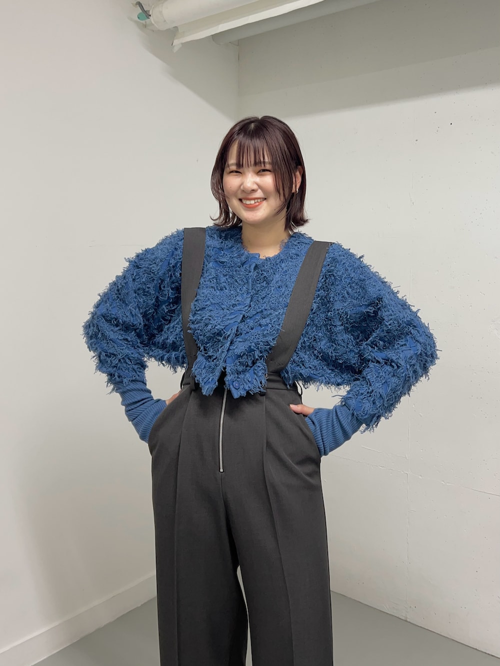 グレー系のサロペット/オーバーオール、ブルー系のカーディガン/ボレロ、ブラック系のブーツを着用したレディースの冬コーディネートの5枚目の写真